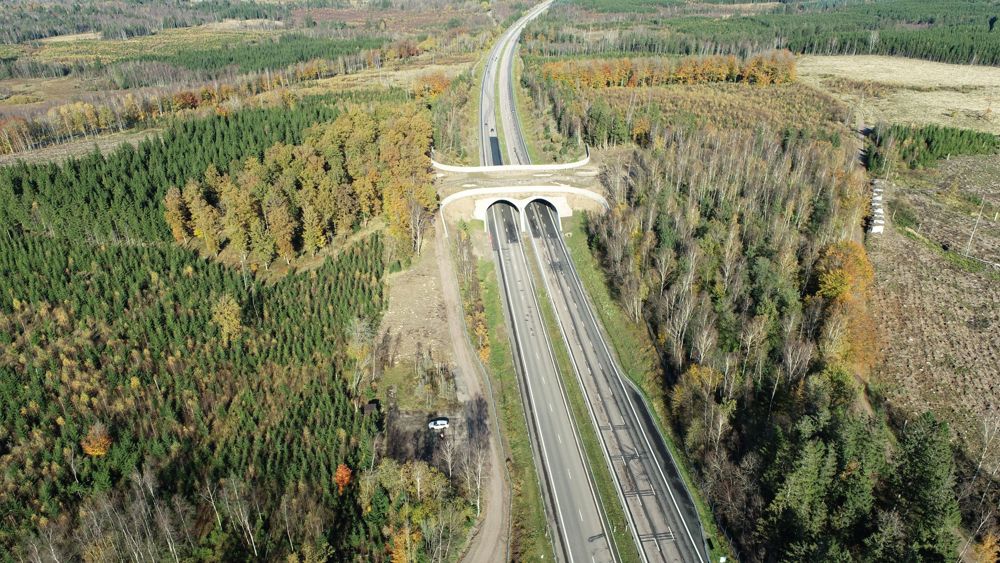 E6:an sträcker sig genom den skogsklädda terrängen och korsas av en ekodukt med två tunnlar