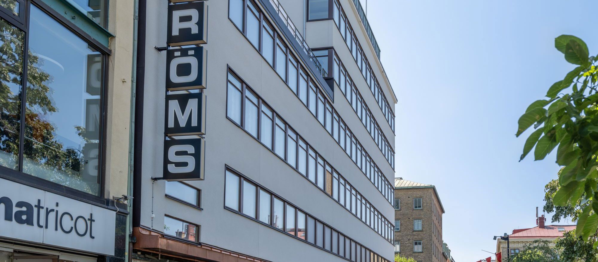 Strömshuset med ljus fasad i flera våningar vid affärsgata
