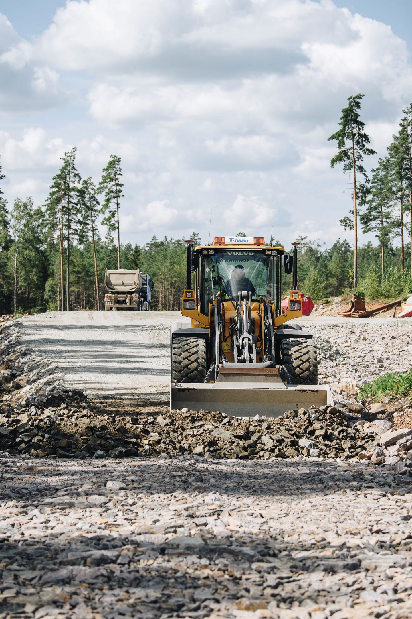 Anläggningsmaskin på nyanlagd väg i skogen under arbetet med Tvinnesheda vindkraftpark