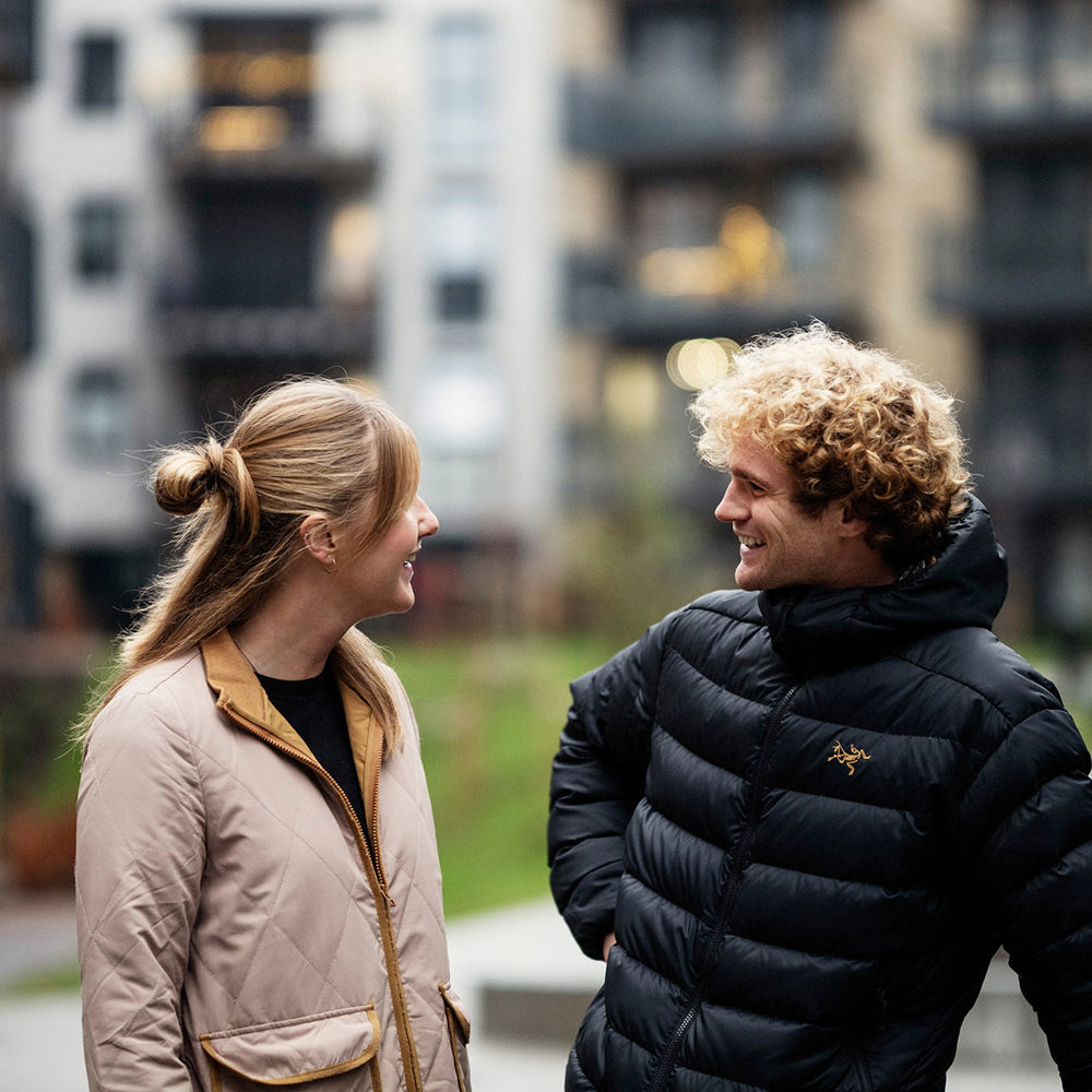 Man och kvinna samtalar i ett bostadskvarter.