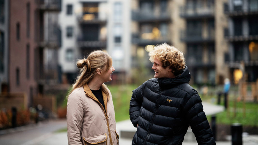 Man och kvinna samtalar i ett bostadskvarter.